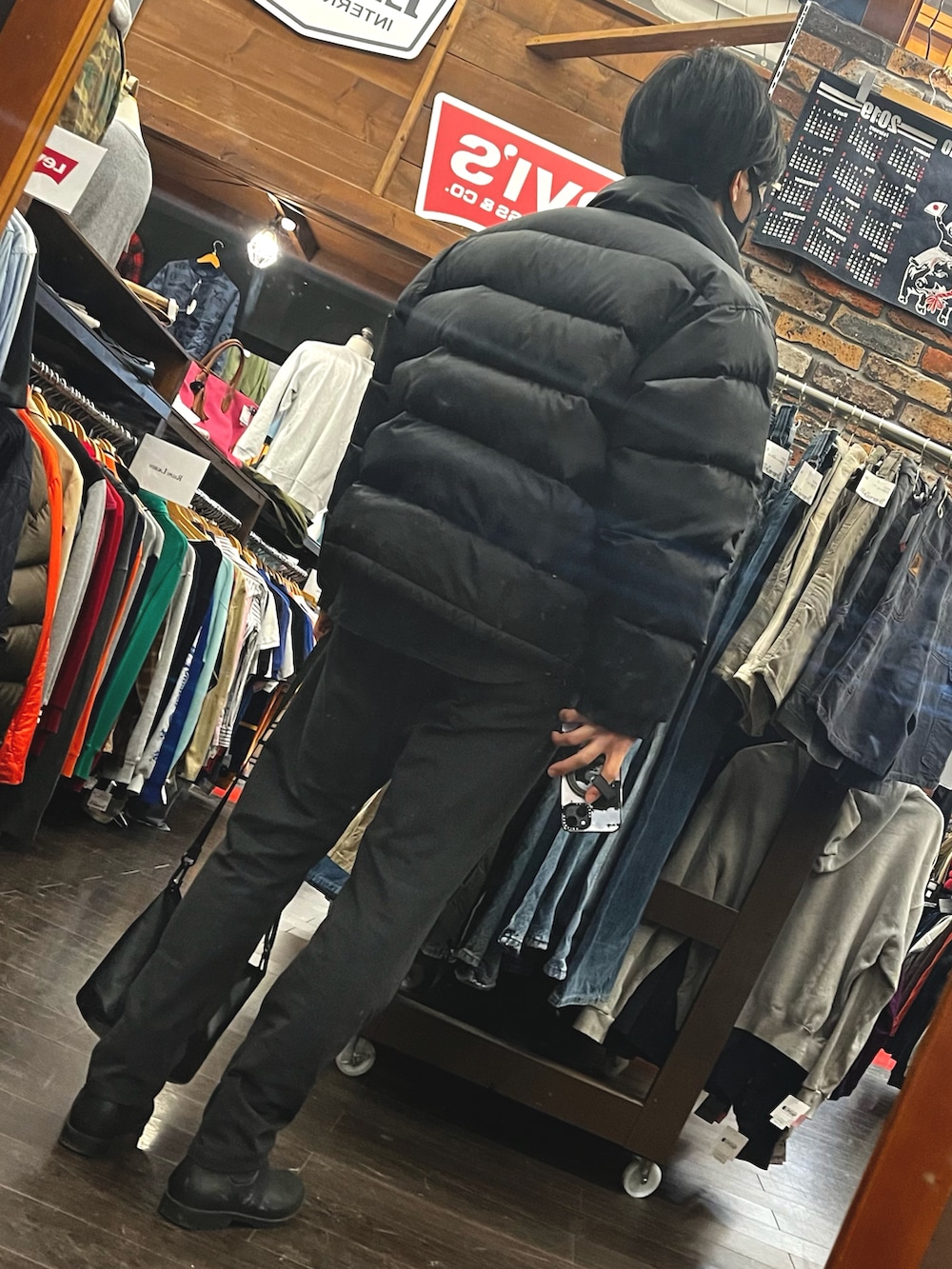 ブラック系のトップス、ブラック系のダウンジャケット/コート、グレー系のその他パンツを着用したメンズの冬コーディネートの2枚目の写真