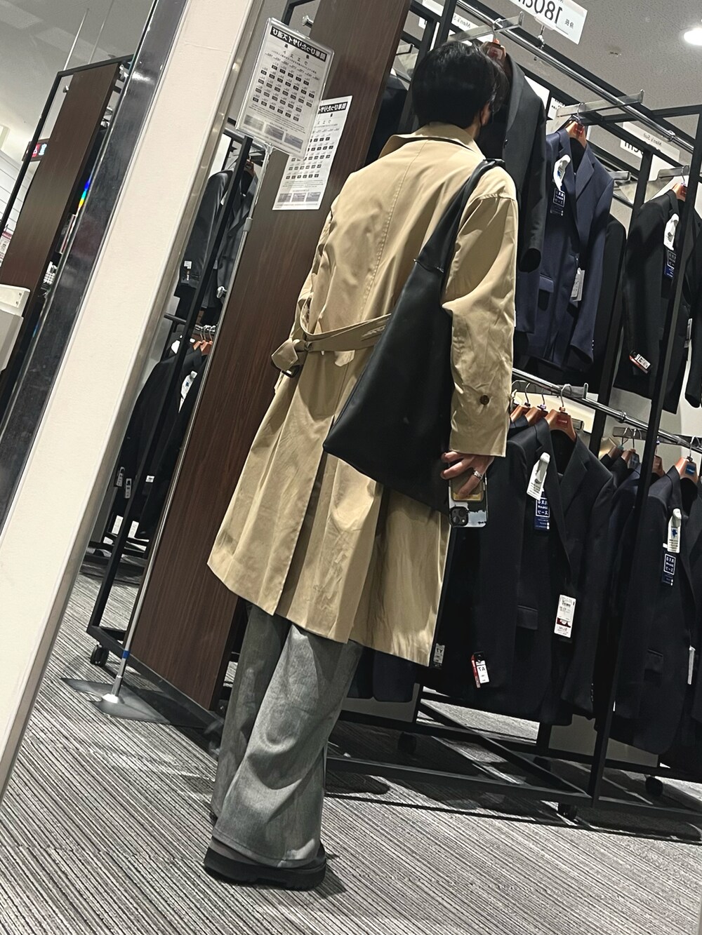 ブラック系のドレスシューズ、グレー系のスラックス、ホワイト系のニット/セーターを着用したメンズの春コーディネートの2枚目の写真