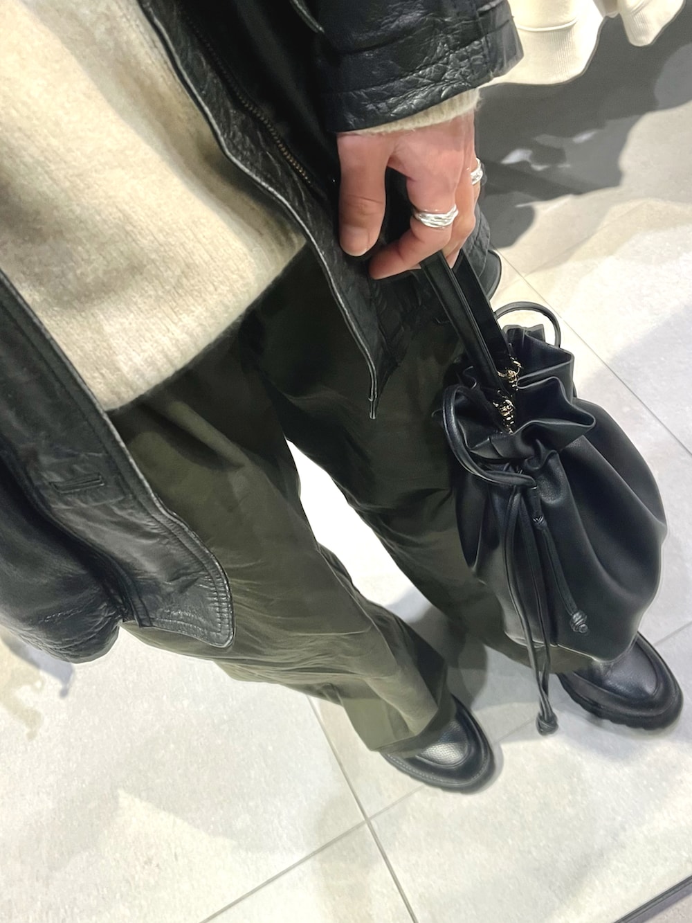 グリーン系のパンツ、ブラック系のドレスシューズ、ブラック系のジャケット/アウターを着用したメンズの冬コーディネートの3枚目の写真