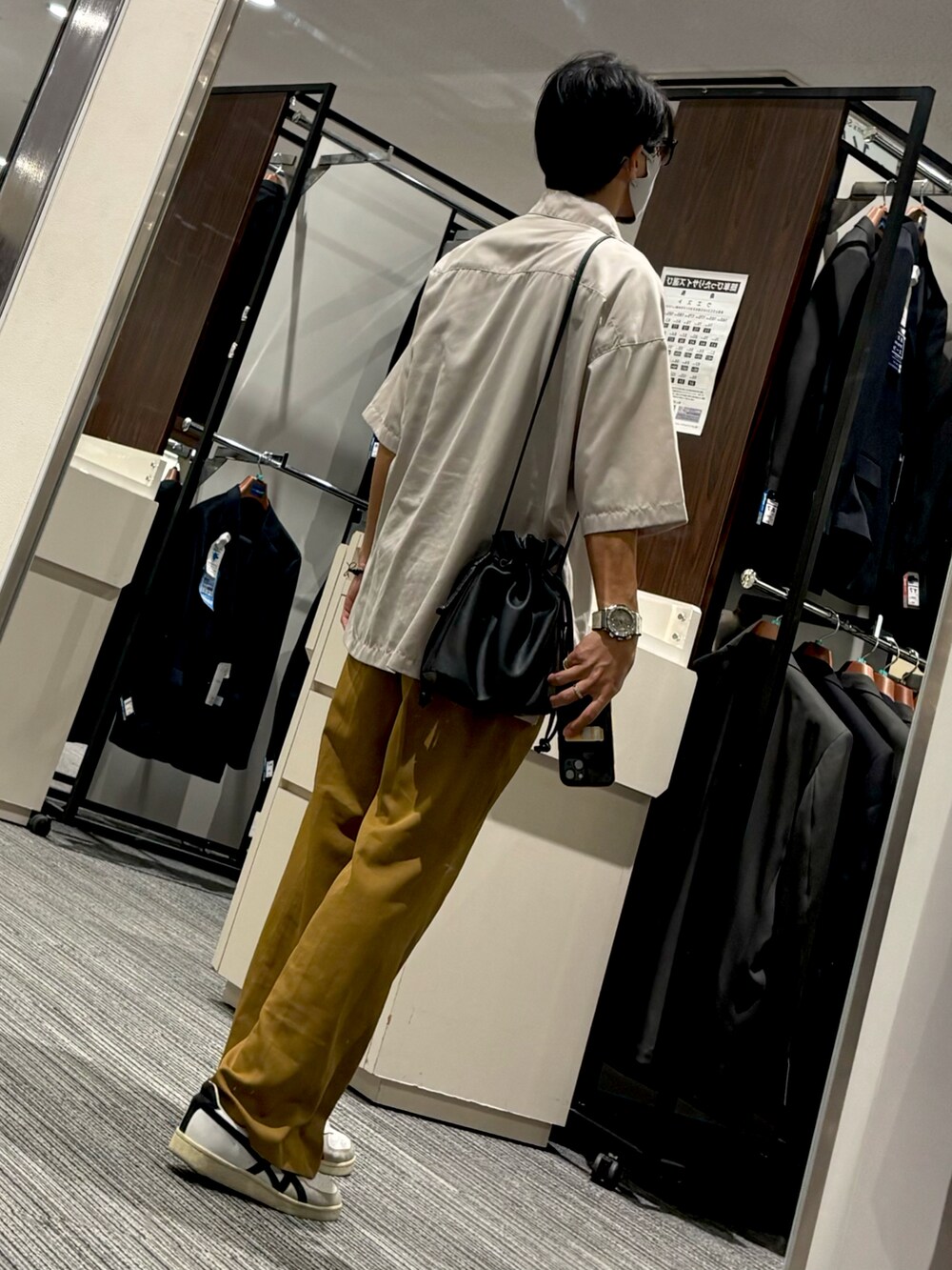 オレンジ系のパンツ、ホワイト系のスニーカー、ブラック系のTシャツ/カットソーを着用したメンズの秋コーディネートの2枚目の写真