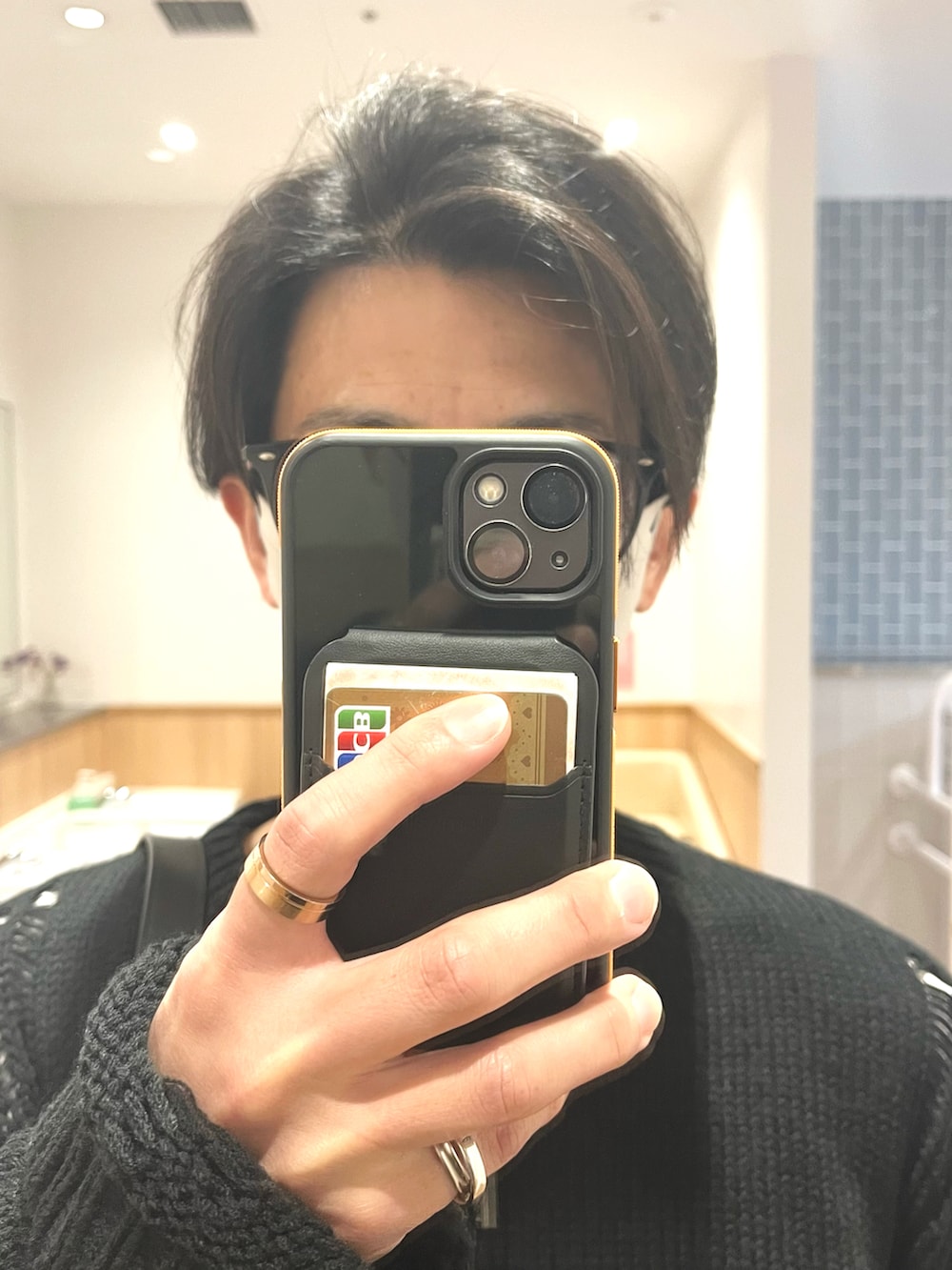 グリーン系のパンツ、ブラック系のドレスシューズ、ブラック系のニット/セーターを着用したメンズの春コーディネートの4枚目の写真