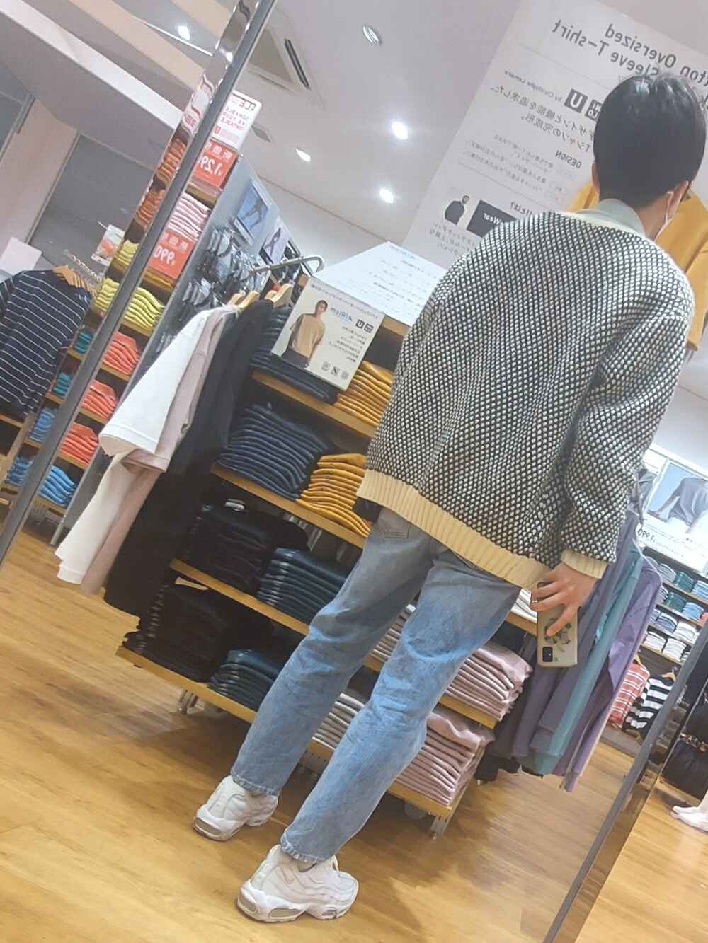 ブルー系のデニムパンツ、ホワイト系のスニーカー、ブラウン系のボディバッグ/ウエストポーチを着用したメンズの春コーディネートの2枚目の写真