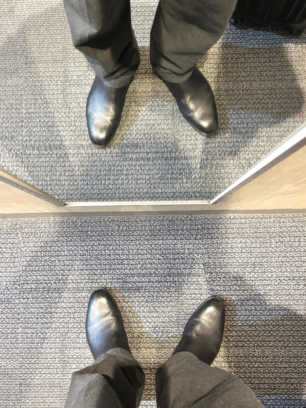 グレー系のスラックス、その他のビジネスシャツ、ブラック系のブルゾンを着用したメンズの春コーディネートの5枚目の写真