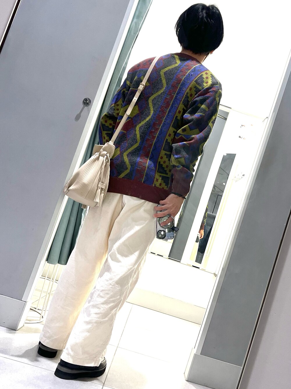 ホワイト系のパンツ、ブラック系のドレスシューズ、その他のニット/セーターを着用したメンズの春コーディネートの2枚目の写真