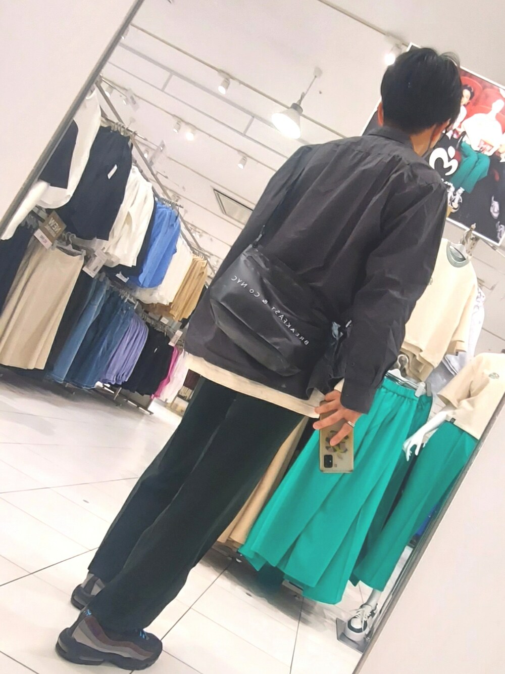 グリーン系のパンツ、ブラック系のスニーカー、ブラック系のシャツ/ブラウスを着用したメンズの春コーディネートの2枚目の写真