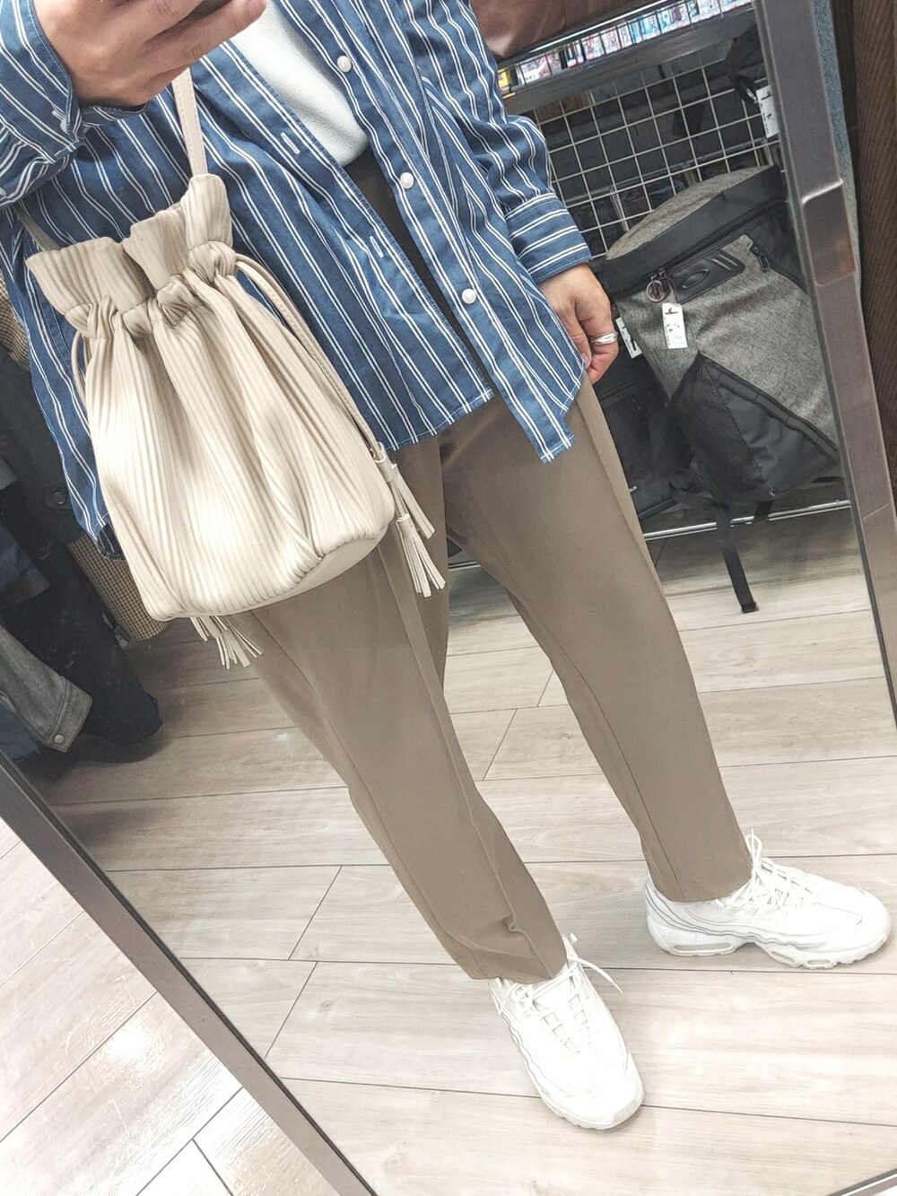 ホワイト系のスニーカー、ベージュ系のパンツ、ホワイト系のボディバッグ/ウエストポーチを着用したメンズの春コーディネートの3枚目の写真