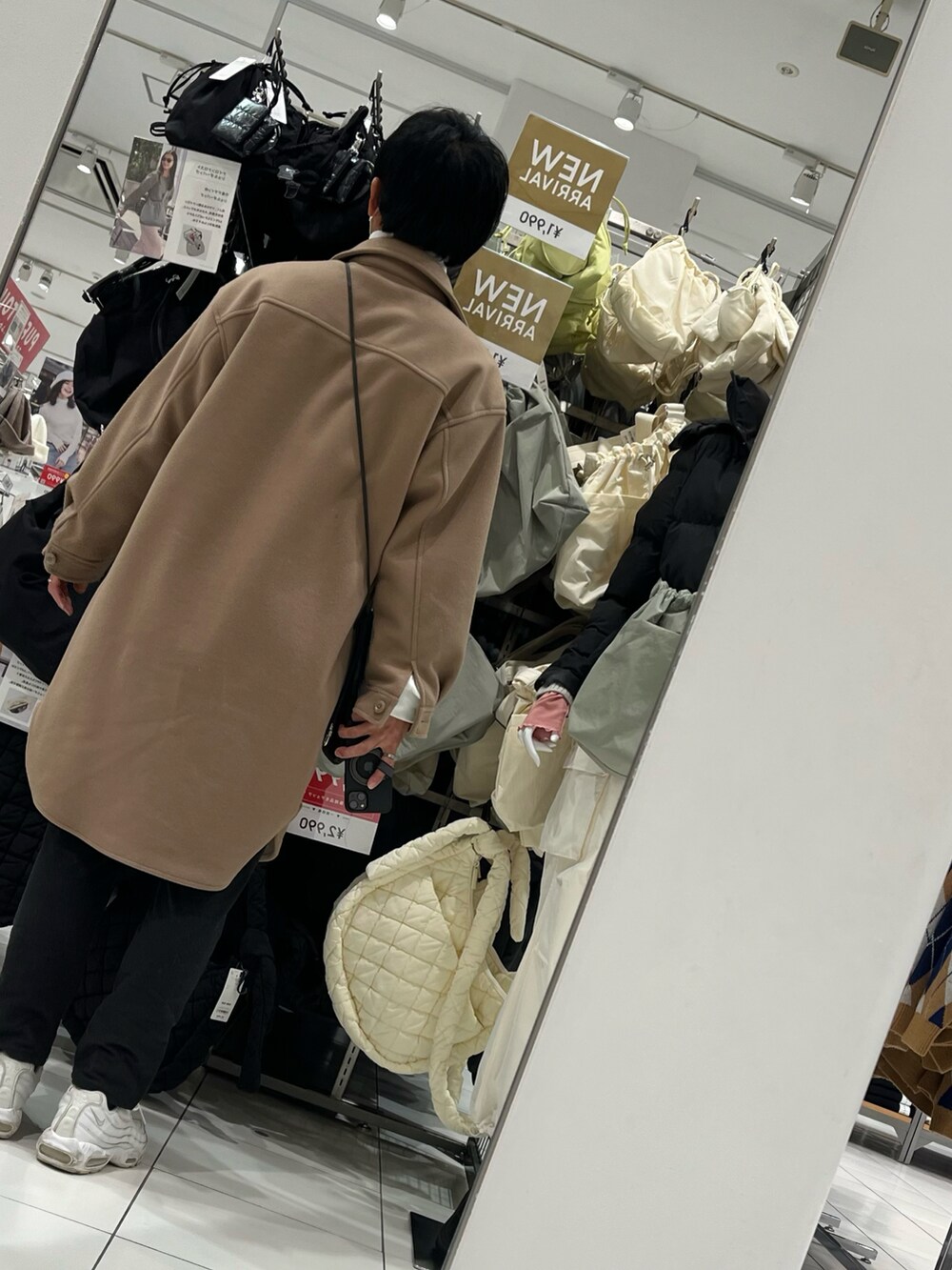 ブラック系のパンツ、ホワイト系のスニーカー、ベージュ系のムートンコートを着用したメンズの冬コーディネートの2枚目の写真