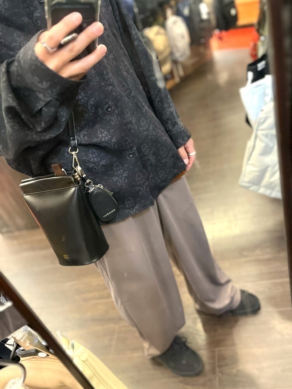 ブラウン系のパンツ、ブラック系のスニーカー、ブラック系のシャツ/ブラウスを着用したメンズの秋コーディネートの3枚目の写真