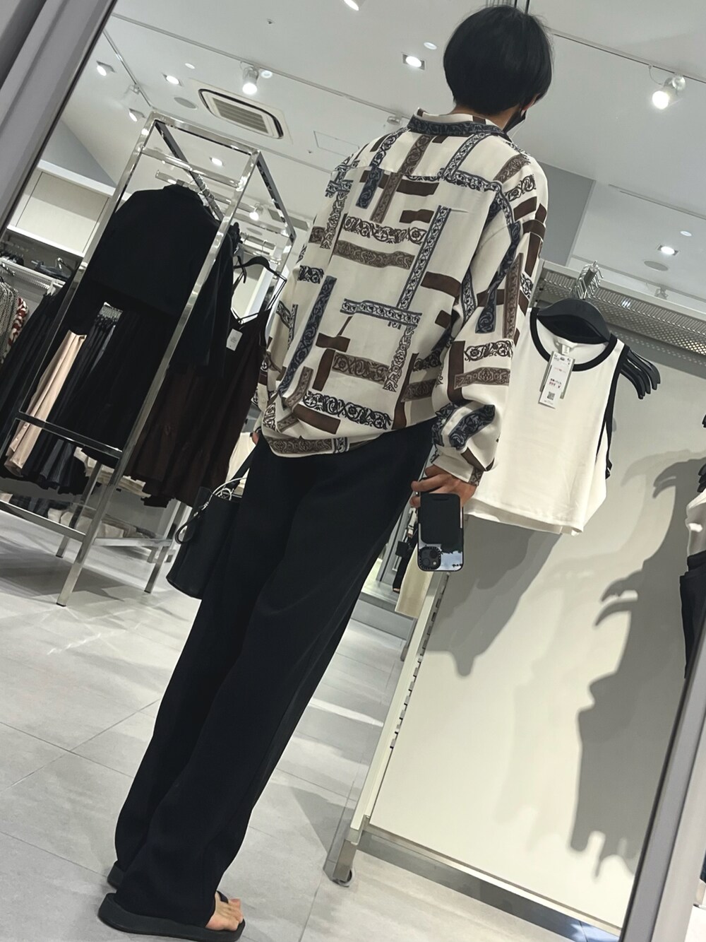 ブラック系のスラックス、ブラック系のサンダル、ブラック系のショルダーバッグを着用したメンズの秋コーディネートの2枚目の写真