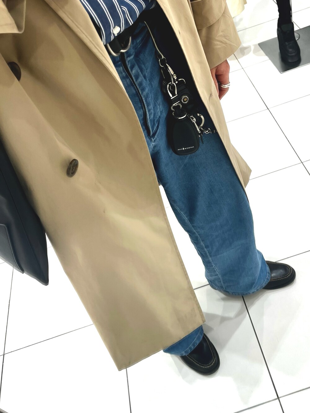 ブラック系のローファー、ブルー系のデニムパンツ、ブラック系のトートバッグを着用したメンズの春コーディネートの3枚目の写真