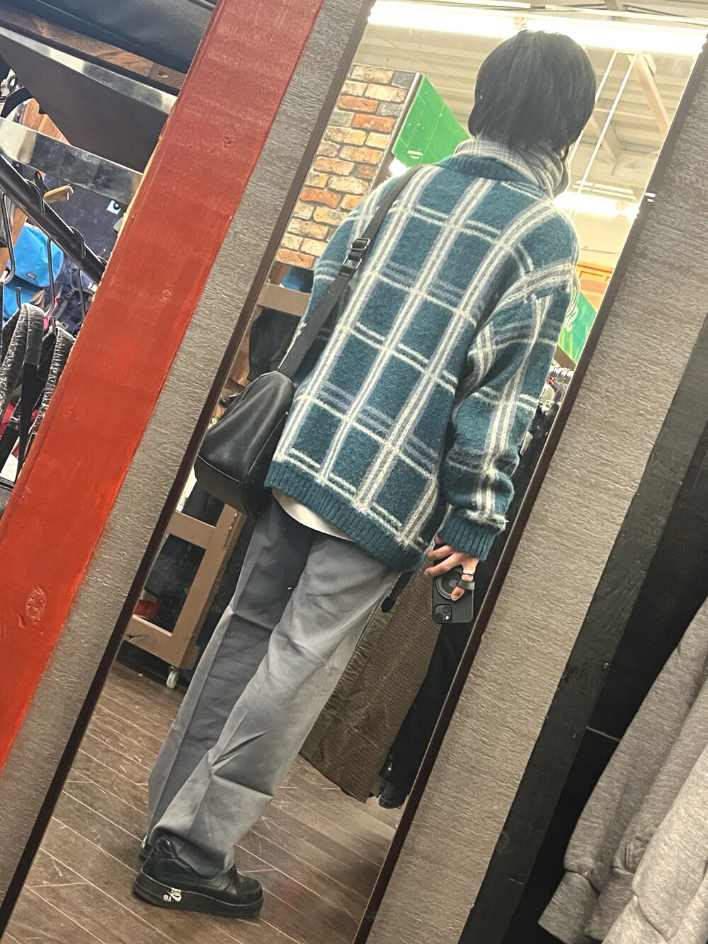 グレー系のパンツ、ブラック系のスニーカー、グリーン系のニット/セーターを着用したメンズの冬コーディネートの2枚目の写真