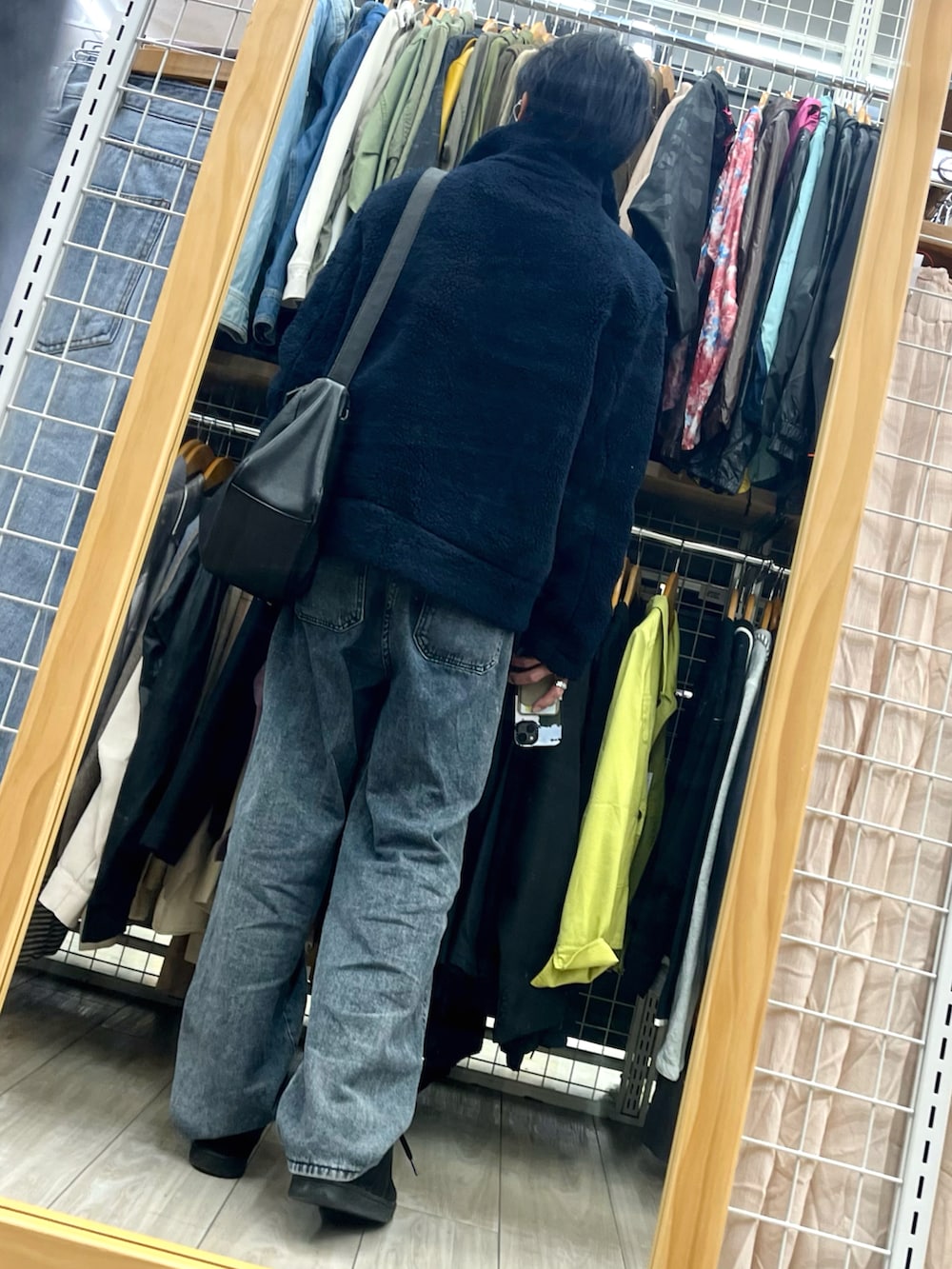 ブラック系のデニムパンツ、ブラック系のスニーカー、ブルー系のブルゾンを着用したメンズの春コーディネートの2枚目の写真