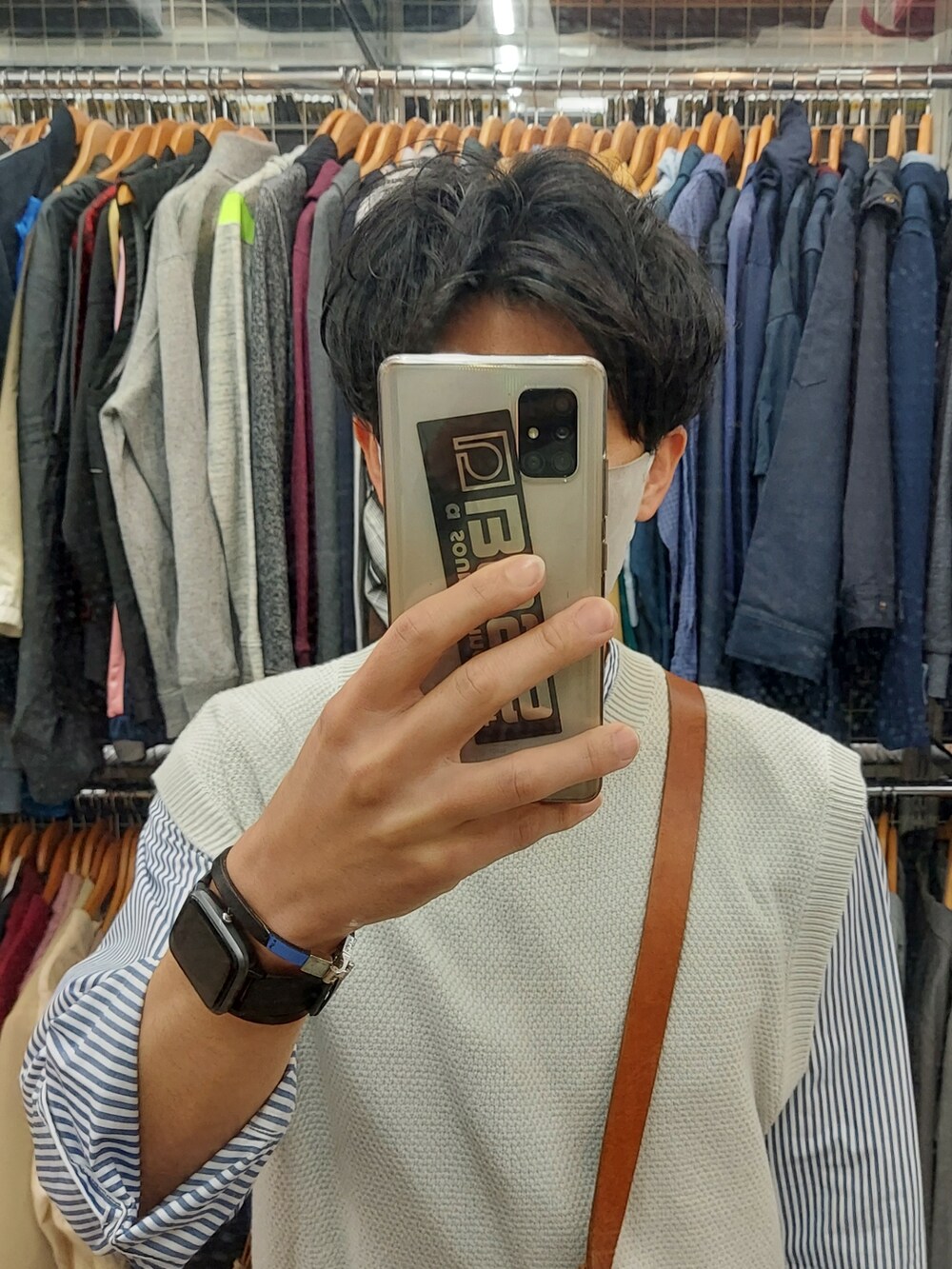 グレー系のベスト、ブラウン系のボディバッグ/ウエストポーチ、ベージュ系のスラックスを着用したメンズの春コーディネートの4枚目の写真