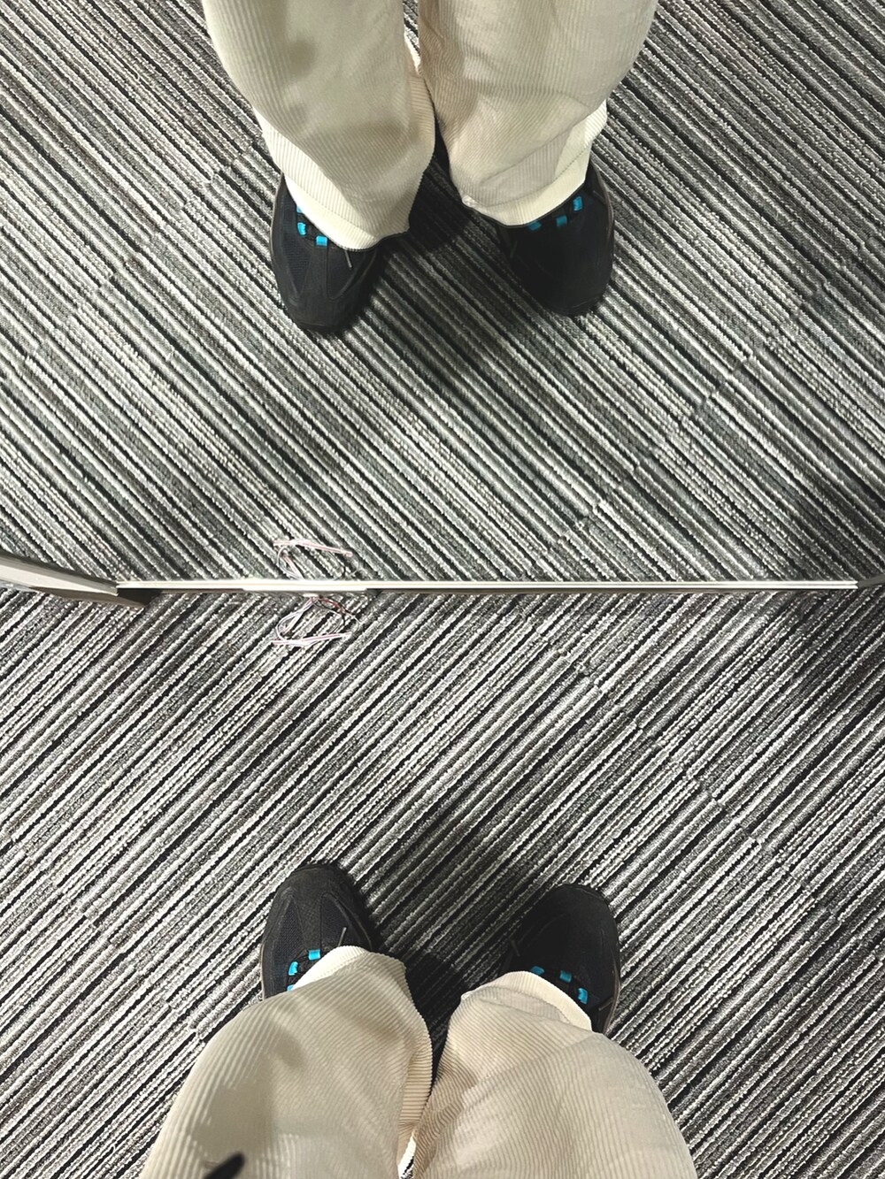 ホワイト系のパンツ、ブラック系のスニーカー、ブラック系のダウンジャケット/コートを着用したメンズの冬コーディネートの5枚目の写真