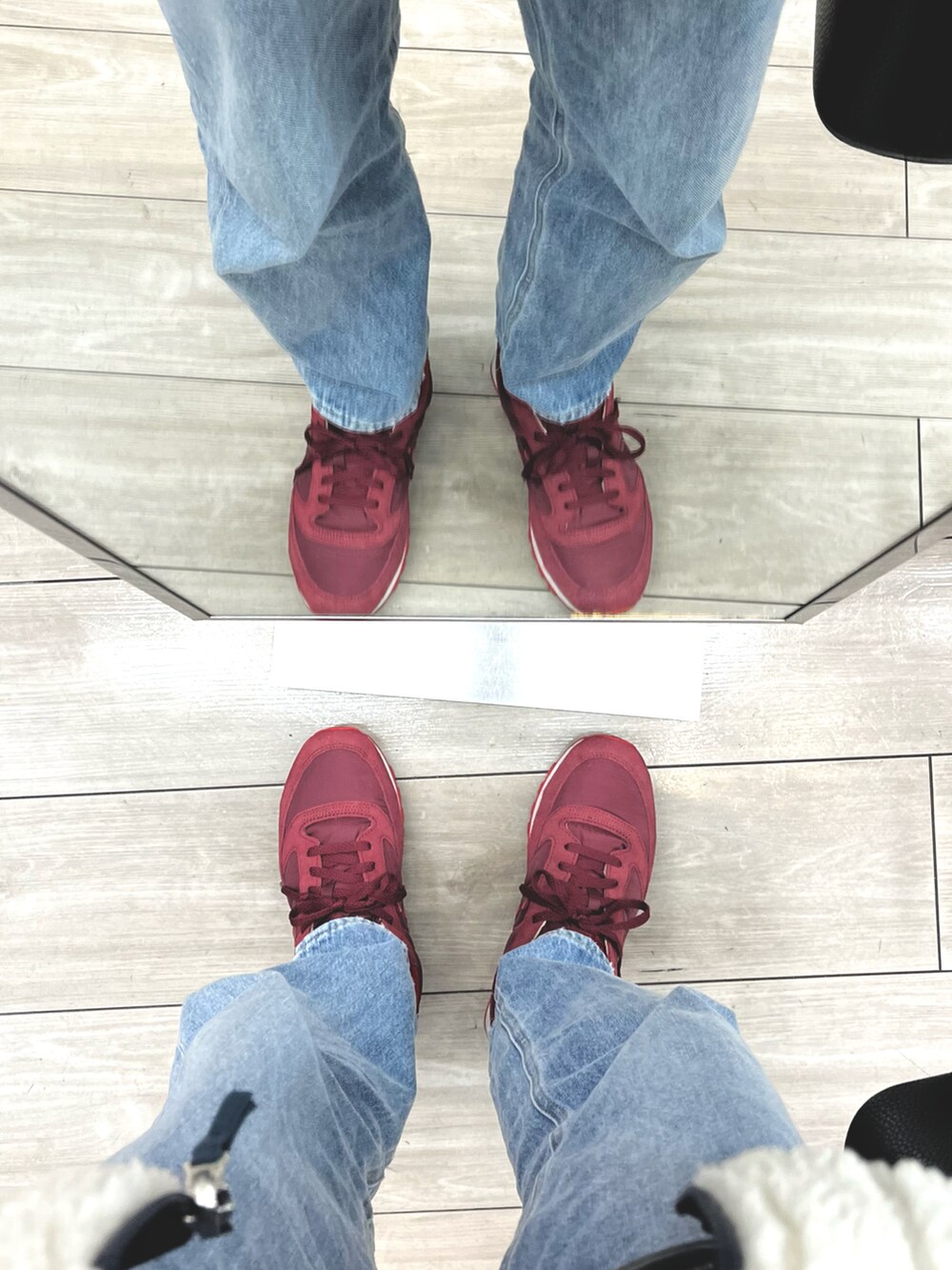 ブルー系のデニムパンツ、レッド系のスニーカー、ホワイト系のブルゾンを着用したメンズの春コーディネートの5枚目の写真