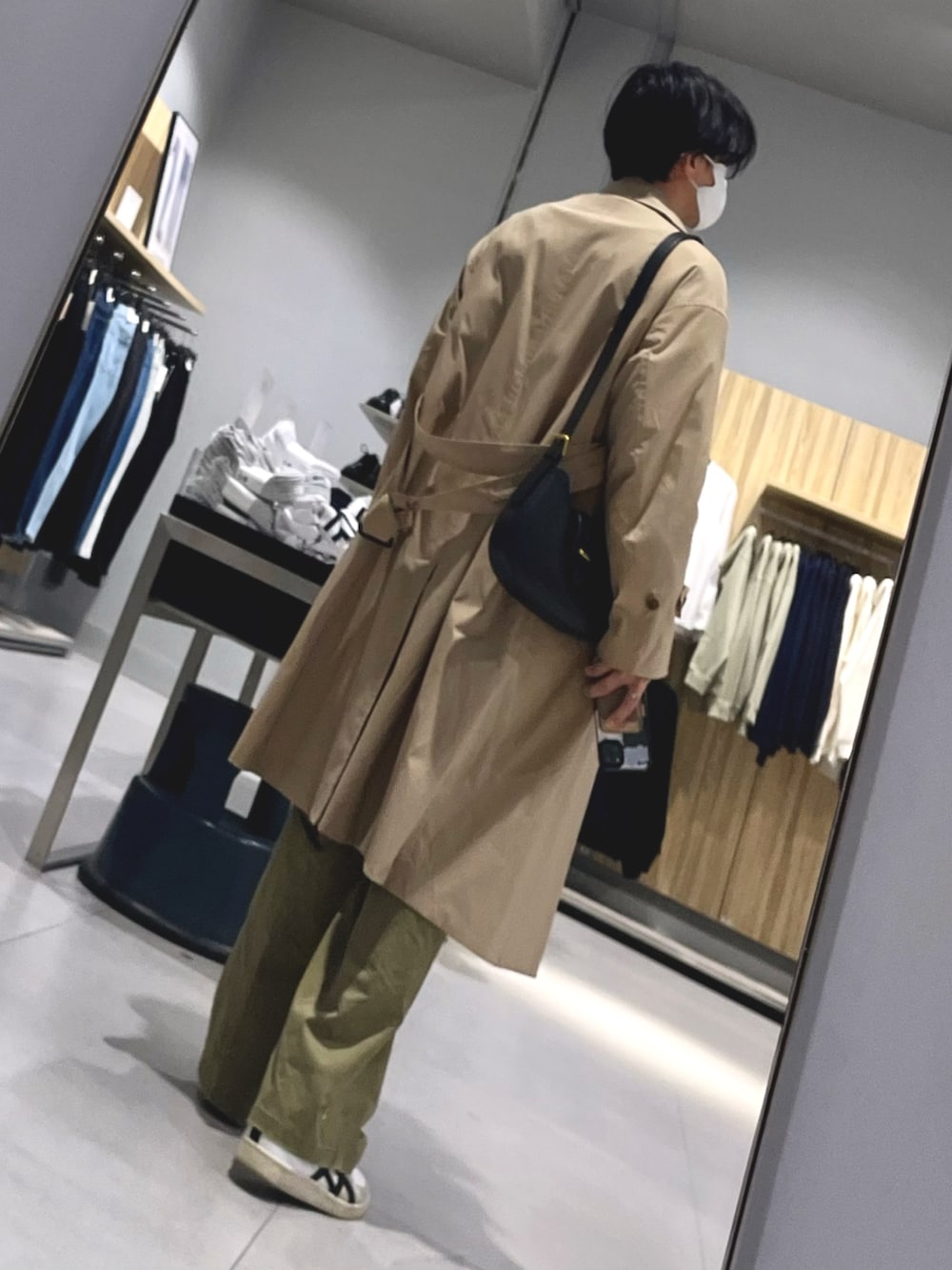 ブラック系のショルダーバッグ、グリーン系のパンツ、ホワイト系のスニーカーを着用したメンズの春コーディネートの2枚目の写真