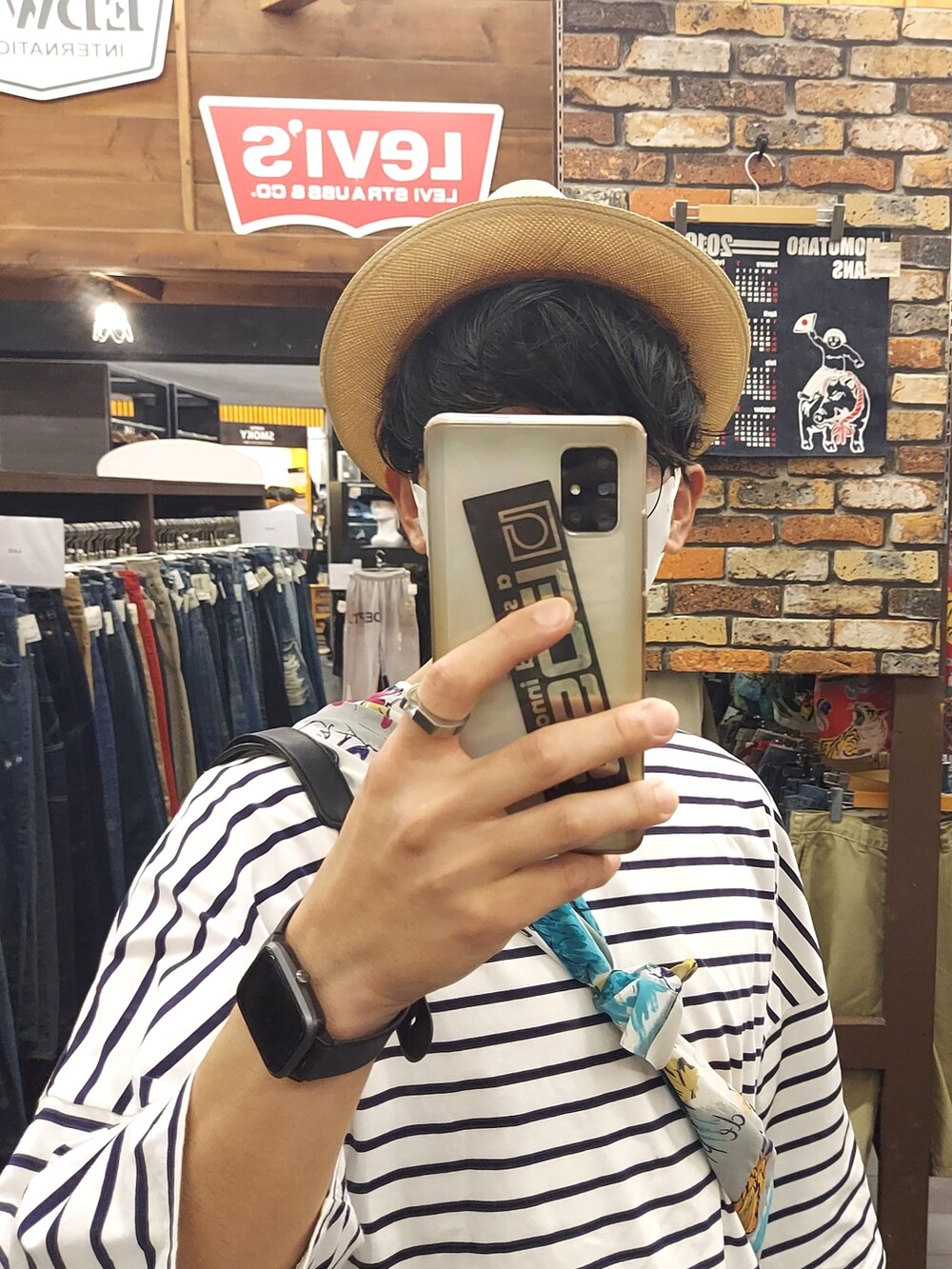 ブルー系のデニムパンツ、ホワイト系のTシャツ/カットソー、ブラック系のサンダルを着用したメンズの夏コーディネートの4枚目の写真