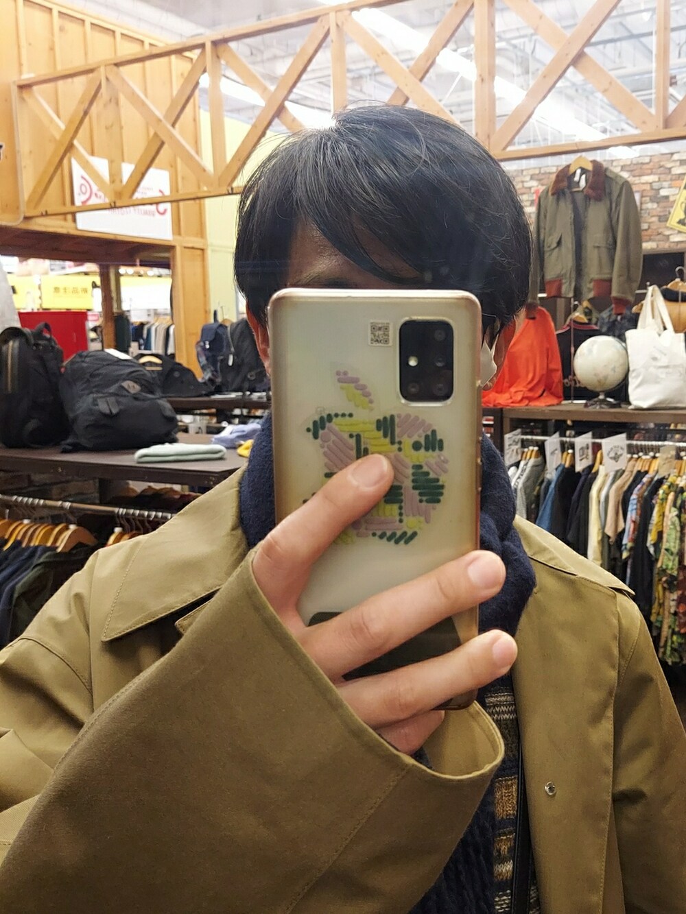 ホワイト系のスニーカー、ブラック系のバッグ、グリーン系のパンツを着用したメンズの冬コーディネートの4枚目の写真