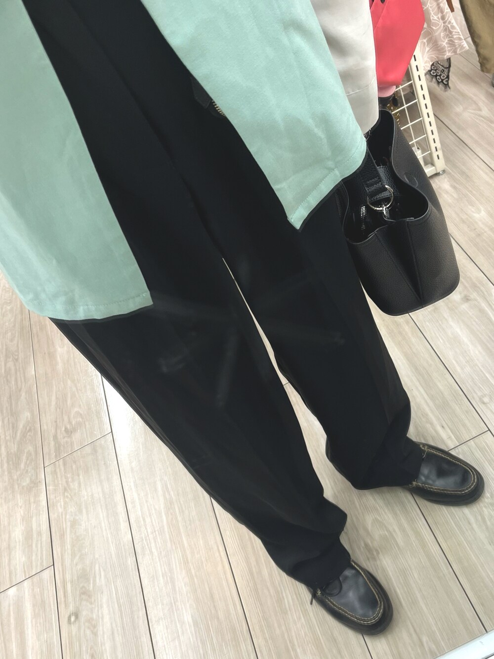 ブラック系のスラックス、ブラック系のローファー、ブラック系のショルダーバッグを着用したメンズの夏コーディネートの3枚目の写真