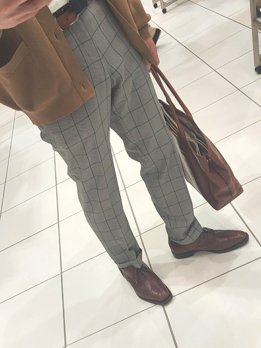 グレー系のスラックス、ブラウン系のドレスシューズ、ブルー系のネクタイを着用したメンズの春コーディネートの3枚目の写真