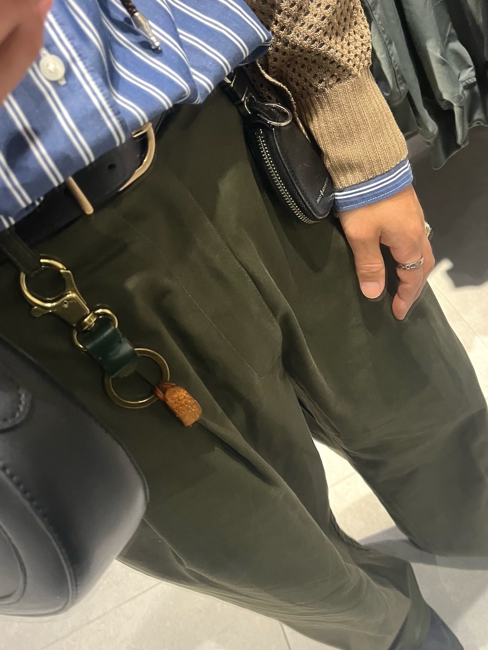 グリーン系のパンツ、ブラック系のスニーカー、ブルー系のシャツ/ブラウスを着用したメンズの秋コーディネートの3枚目の写真