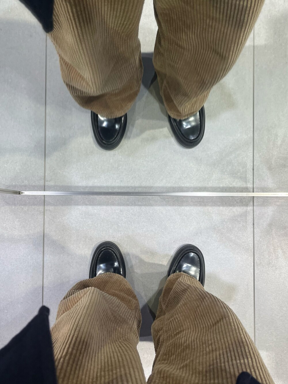 ブラウン系のパンツ、ブラック系のローファー、ブルー系のピーコートを着用したメンズの冬コーディネートの5枚目の写真