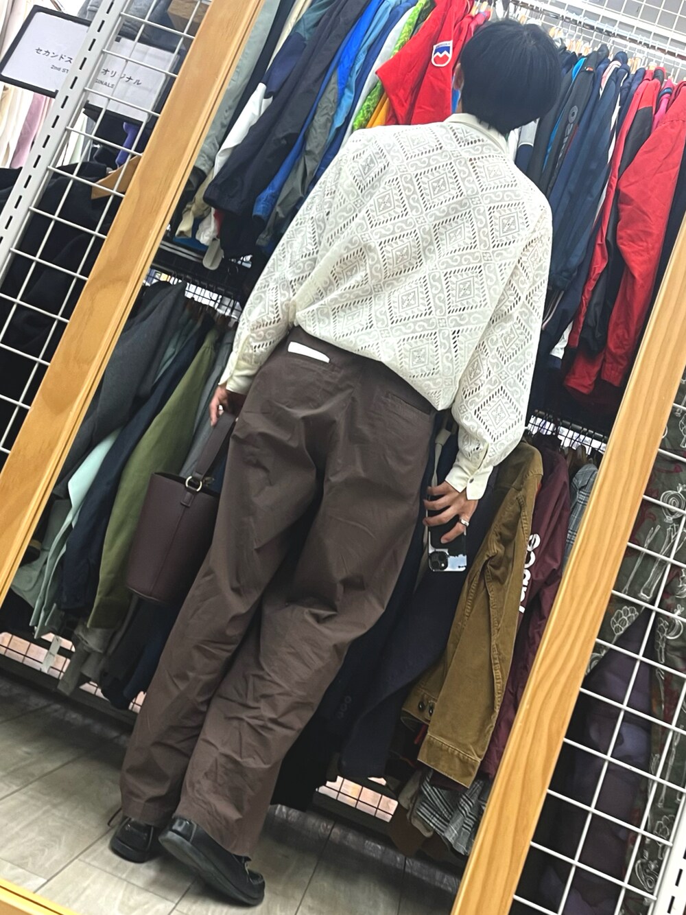 ブラック系のローファー、ブラウン系のハンドバッグ、パープル系のパンツを着用したメンズの秋コーディネートの2枚目の写真