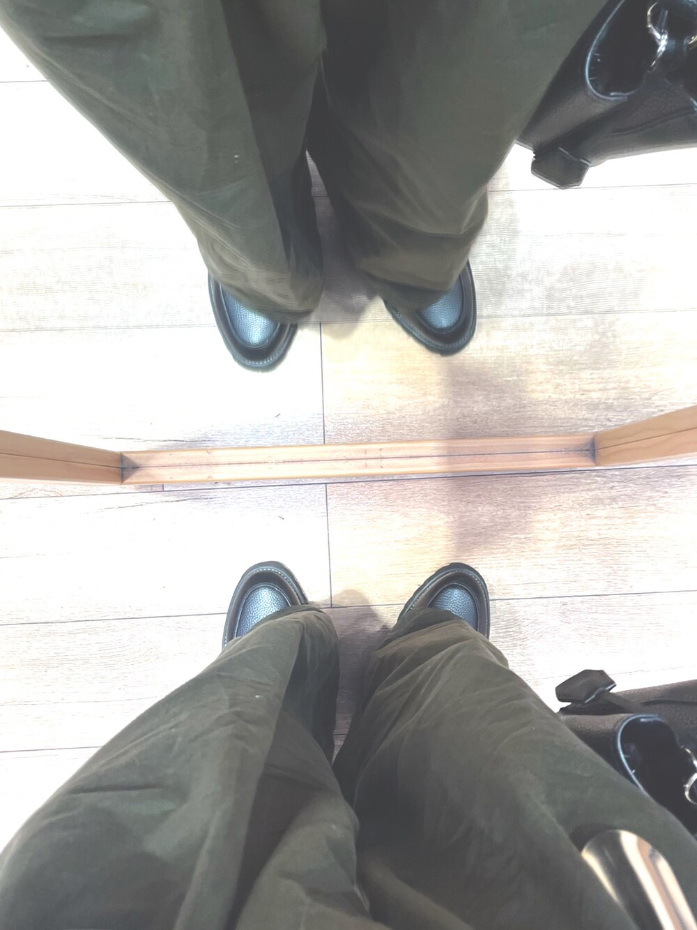 ブラック系のドレスシューズ、ブラック系のショルダーバッグ、レッド系のニット/セーターを着用したメンズの秋コーディネートの5枚目の写真