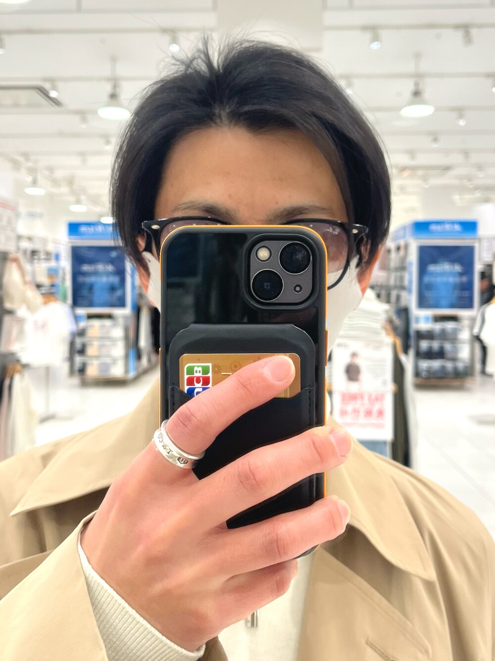 ベージュ系のトレンチコート、グレー系のスラックス、ブラック系のショルダーバッグを着用したメンズの春コーディネートの4枚目の写真