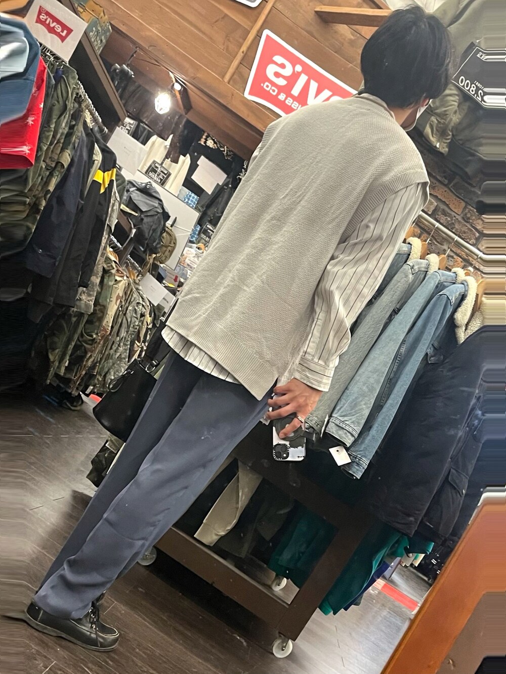 ブルー系のスラックス、ブラック系のローファー、ブラック系のショルダーバッグを着用したメンズの春コーディネートの2枚目の写真