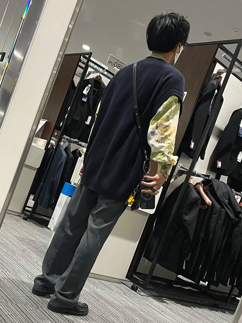 ブルー系のパンツ、ブラック系のローファー、ブルー系のベストを着用したメンズの秋コーディネートの2枚目の写真