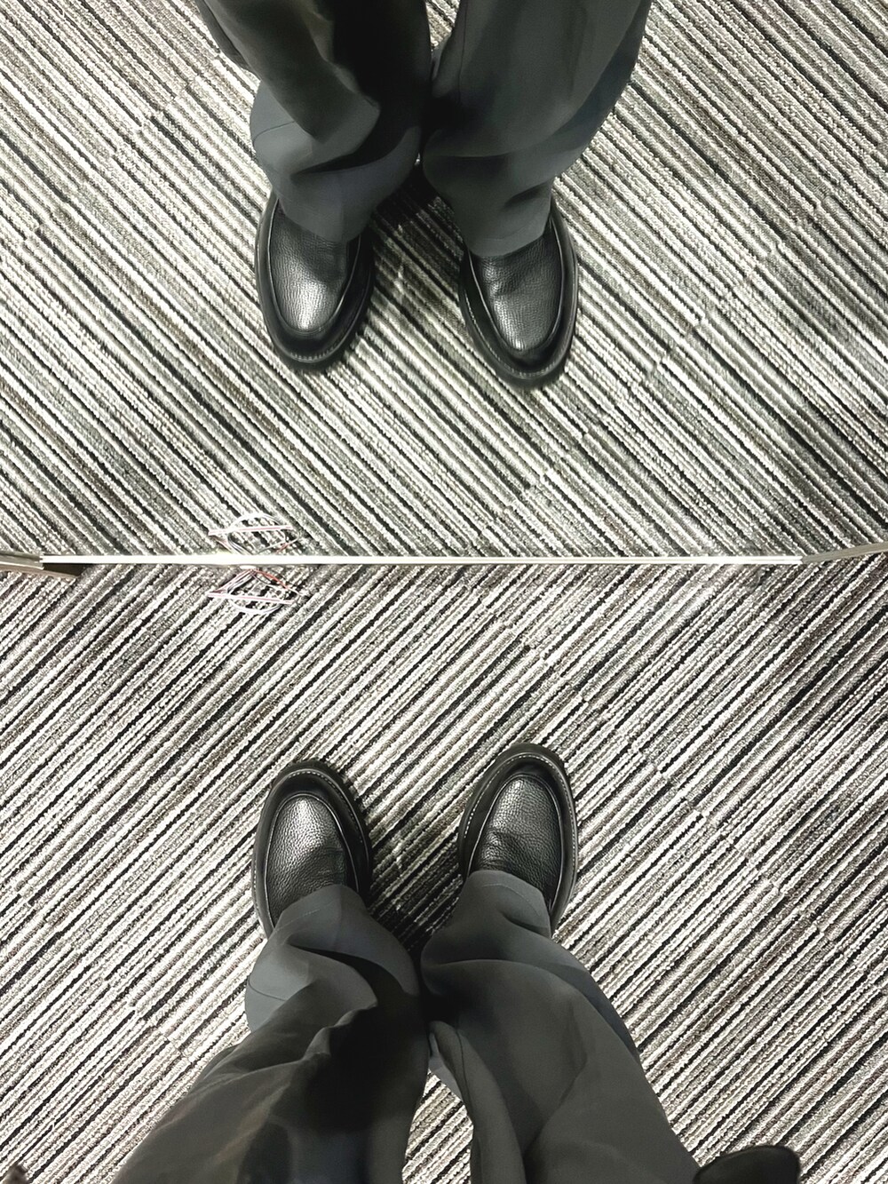 ブラック系のドレスシューズ、グレー系のスラックス、ブルー系のニット/セーターを着用したメンズの冬コーディネートの5枚目の写真