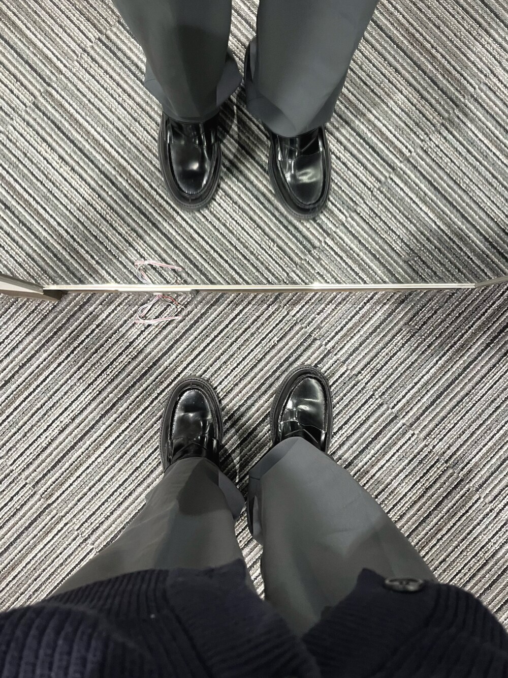 ブルー系のパンツ、ブラック系のローファー、ブルー系のベストを着用したメンズの秋コーディネートの5枚目の写真