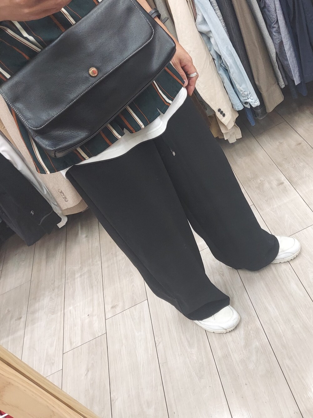 ブラック系のパンツ、ブラック系のバッグ、ホワイト系のタンクトップを着用したメンズの秋コーディネートの3枚目の写真
