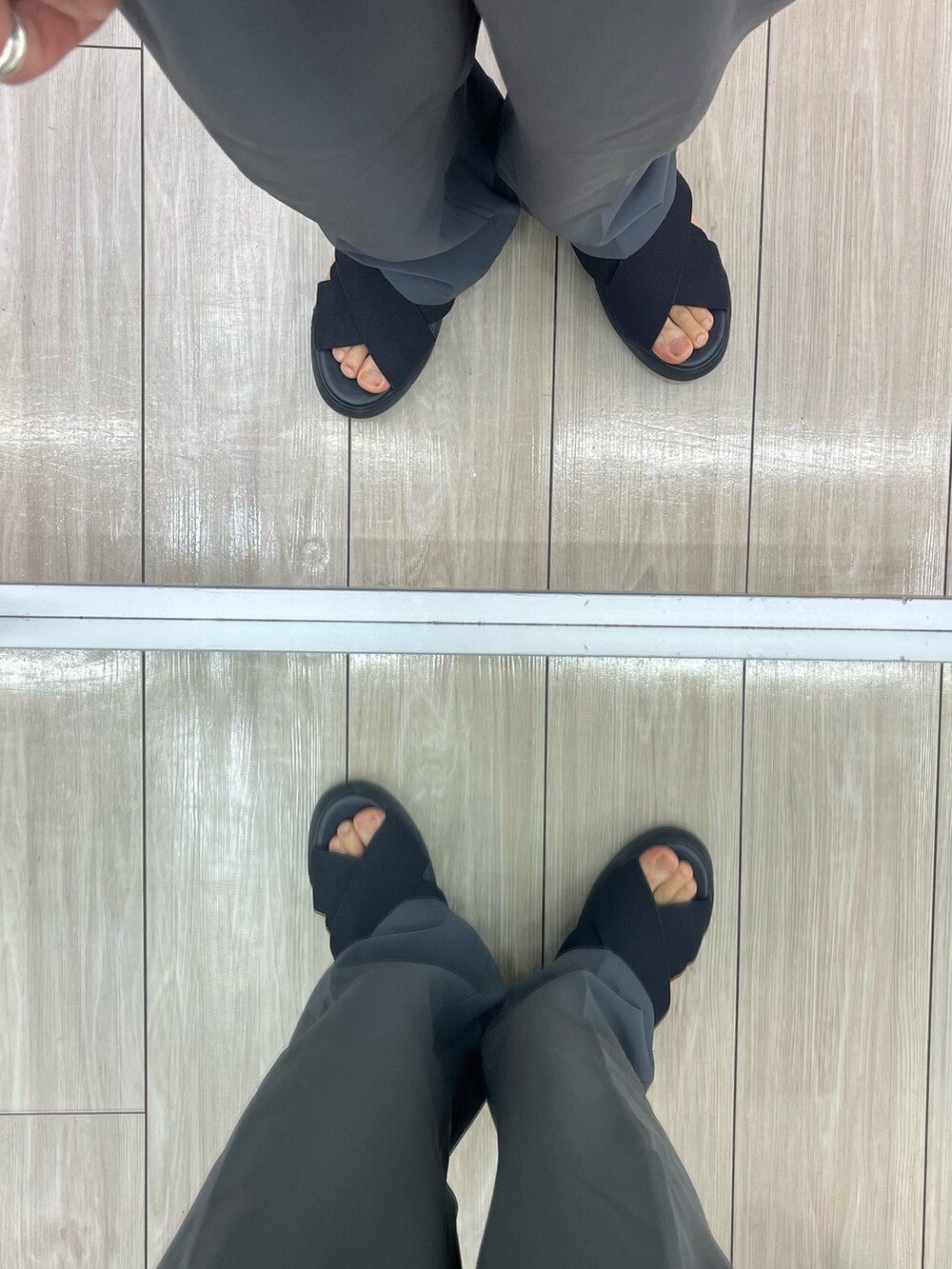 ブラック系のサンダル、グレー系のスラックス、ブラック系のショルダーバッグを着用したメンズの夏コーディネートの5枚目の写真