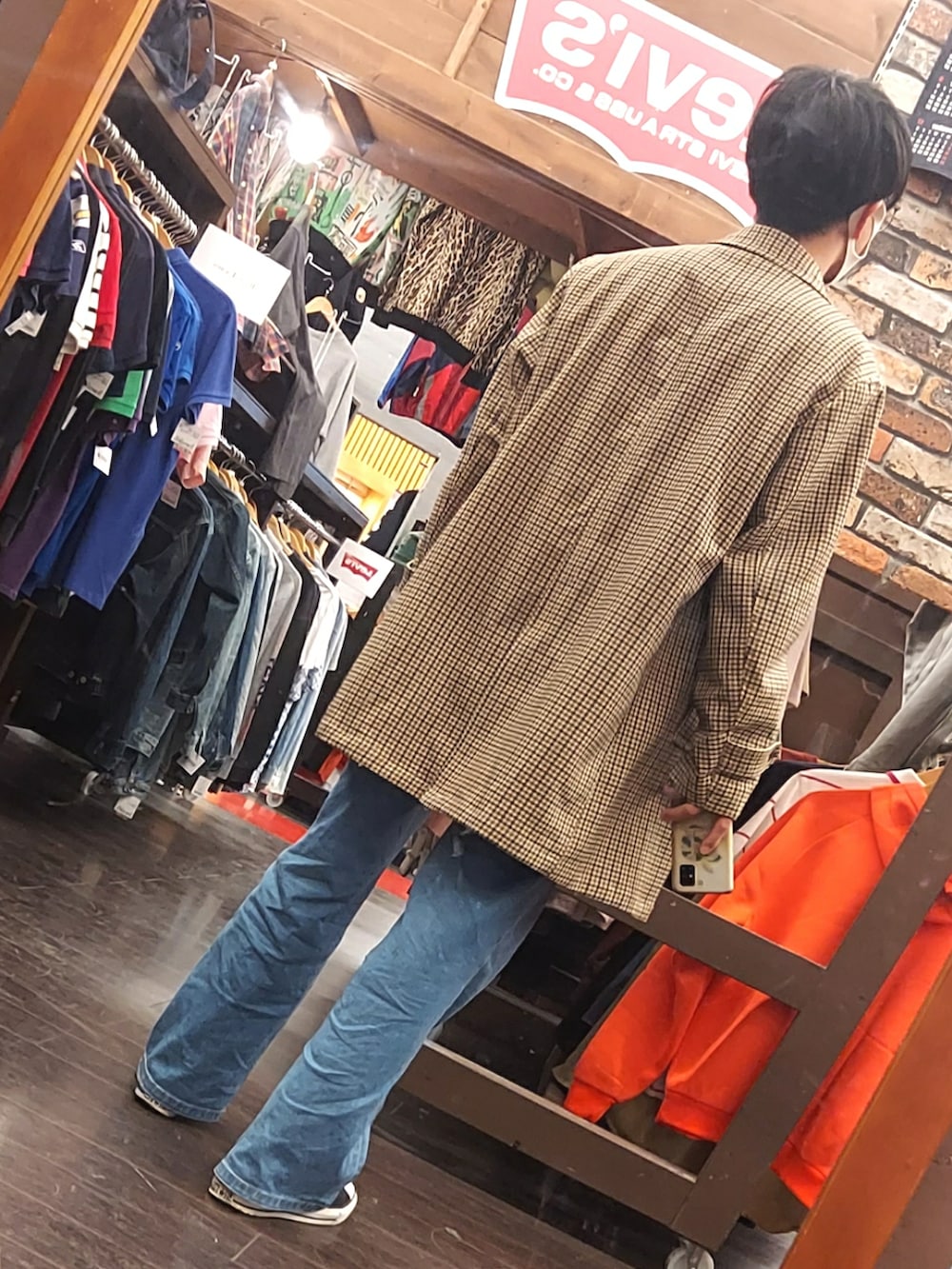 ブルー系のデニムパンツ、ブラック系のスニーカー、ブラウン系のボディバッグ/ウエストポーチを着用したメンズの春コーディネートの2枚目の写真