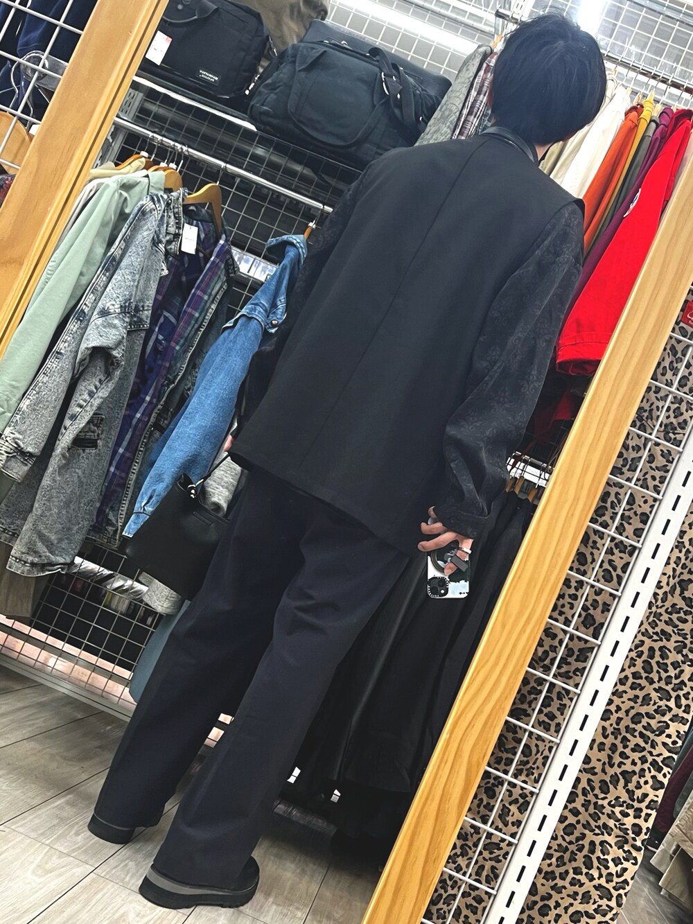 ブラック系のスラックス、ブラック系のドレスシューズ、ブラック系のショルダーバッグを着用したメンズの春コーディネートの2枚目の写真