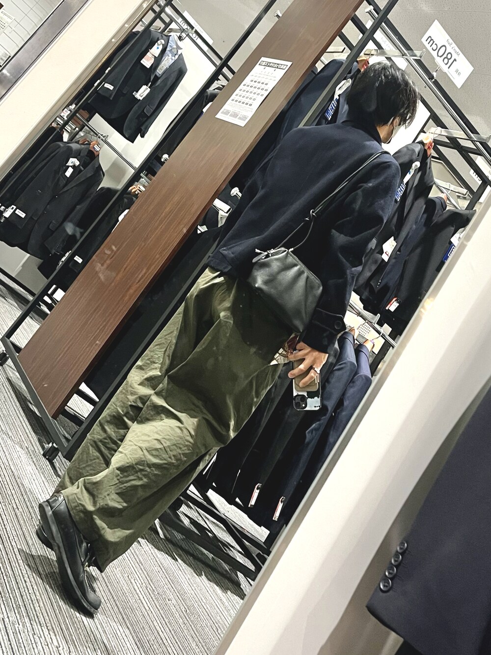 ブラック系のローファー、グリーン系のパンツ、ブラック系のショルダーバッグを着用したメンズの冬コーディネートの2枚目の写真