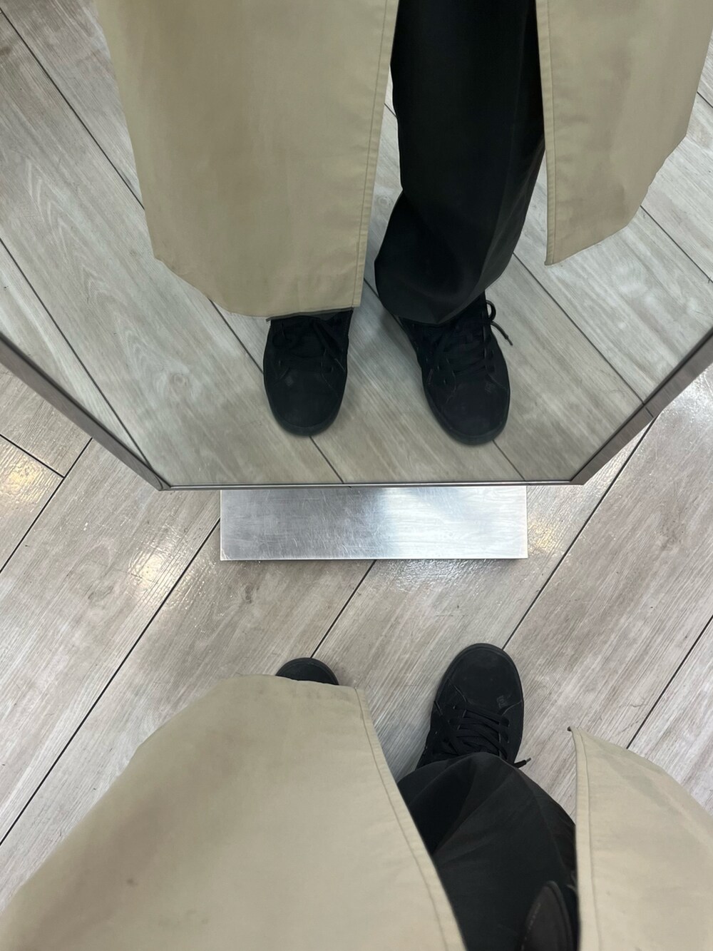 ブラック系のスニーカー、ベージュ系のトレンチコート、ブラック系のショルダーバッグを着用したメンズの冬コーディネートの5枚目の写真