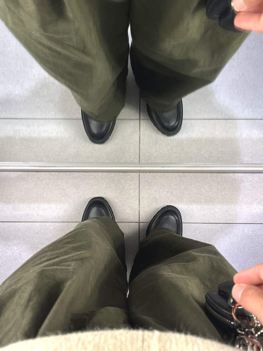 グリーン系のパンツ、ブラック系のドレスシューズ、ブラック系のジャケット/アウターを着用したメンズの冬コーディネートの5枚目の写真