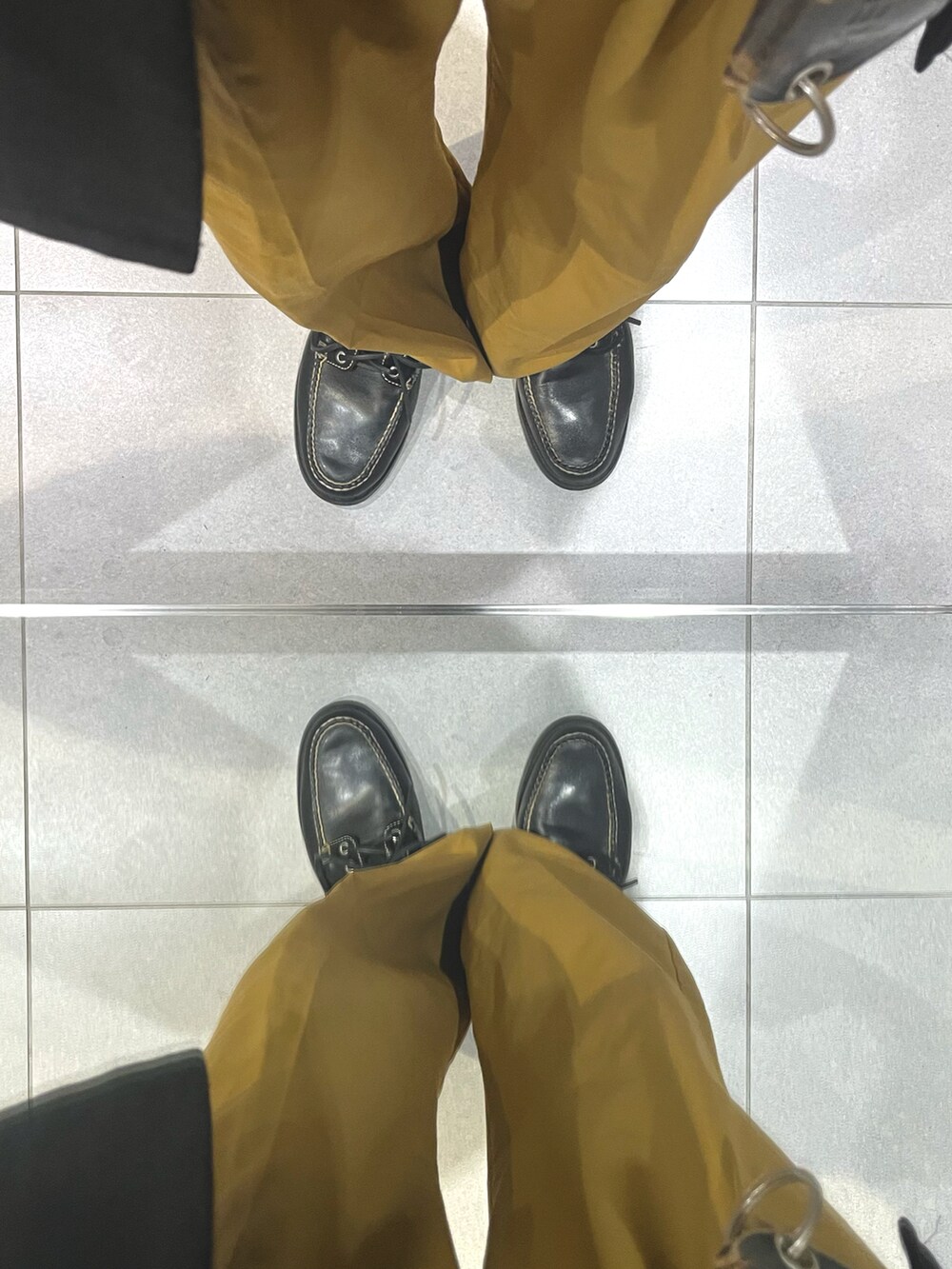 ブラック系のローファー、オレンジ系のパンツ、ホワイト系のシャツ/ブラウスを着用したメンズの秋コーディネートの5枚目の写真