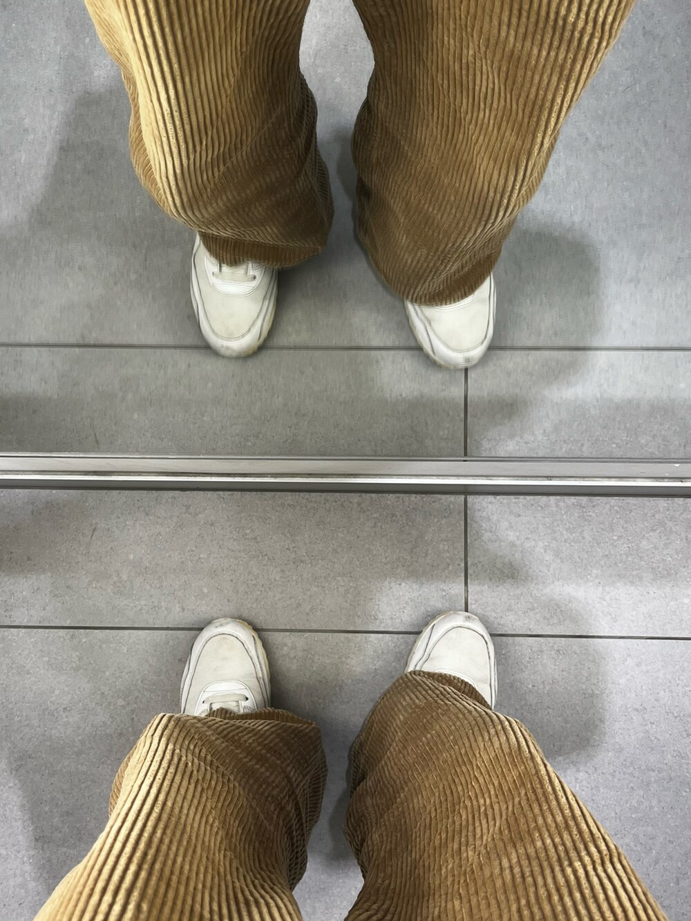 ブラウン系のパンツ、ホワイト系のスニーカー、ベージュ系のシャツ/ブラウスを着用したメンズの冬コーディネートの5枚目の写真