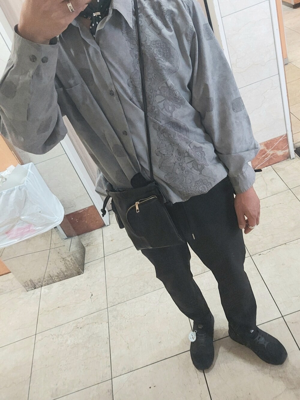 ブラック系のスニーカー、ブラック系のスラックス、ブラック系のショルダーバッグを着用したメンズの春コーディネートの3枚目の写真