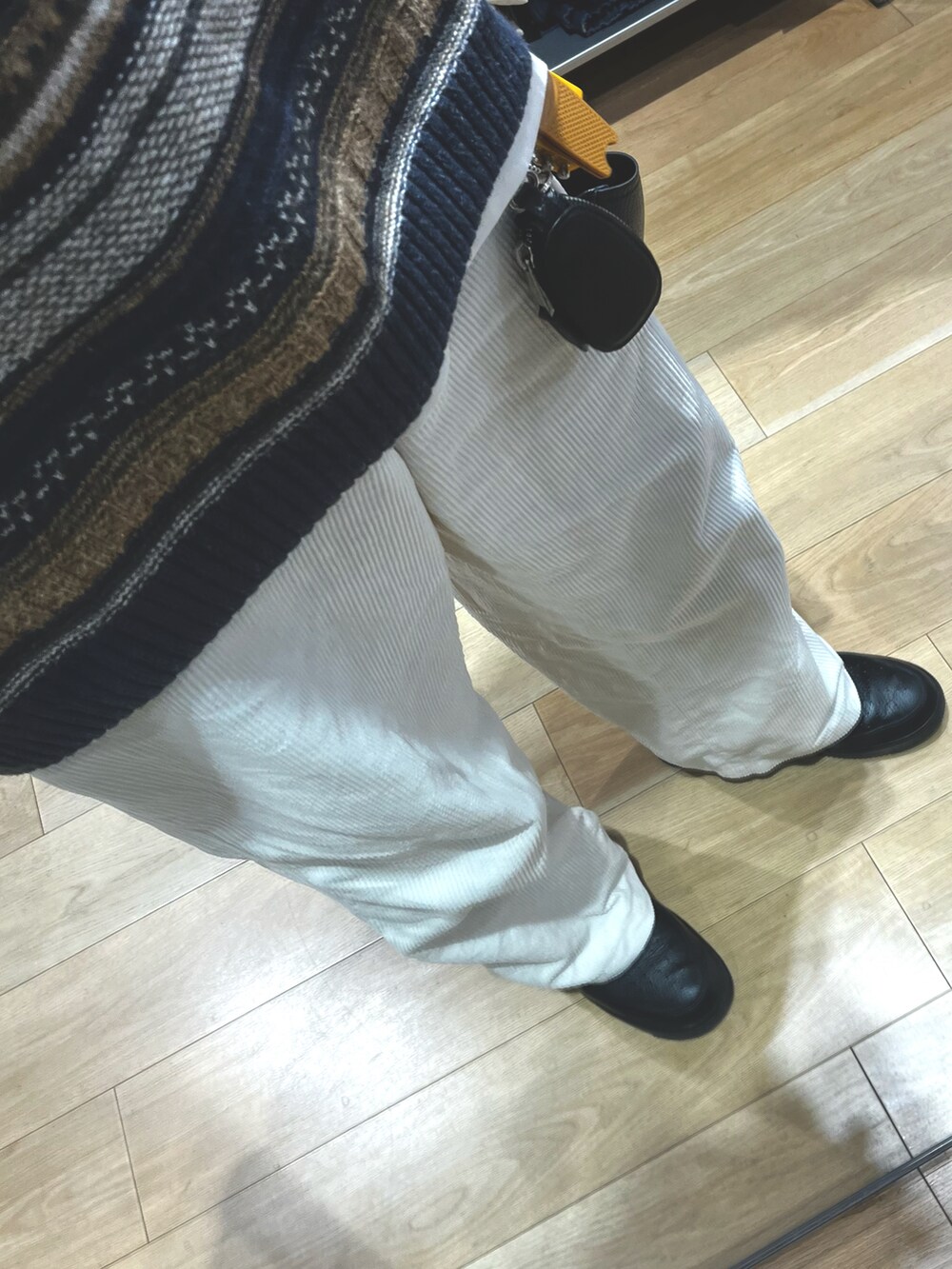 ホワイト系のパンツ、ブラック系のスニーカー、ブラック系のショルダーバッグを着用したメンズの冬コーディネートの3枚目の写真