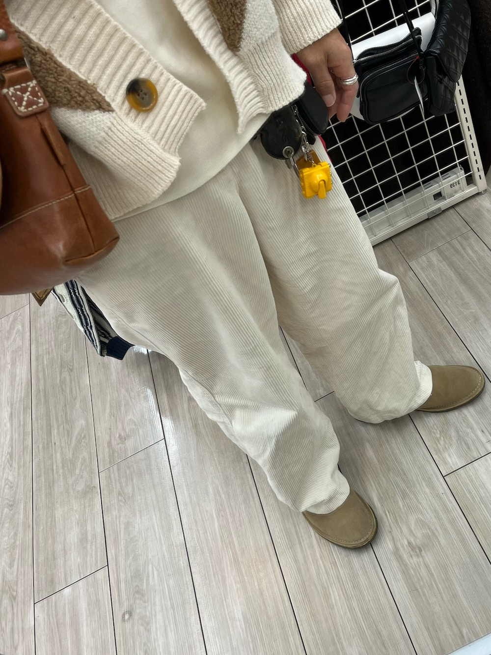 ホワイト系のパンツ、ベージュ系のシューズ、ベージュ系のカーディガン/ボレロを着用したメンズの秋コーディネートの3枚目の写真