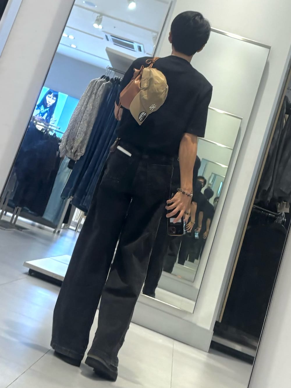 ブラック系のデニムパンツ、ブラック系のドレスシューズ、ブラック系のTシャツ/カットソーを着用したメンズの秋コーディネートの2枚目の写真