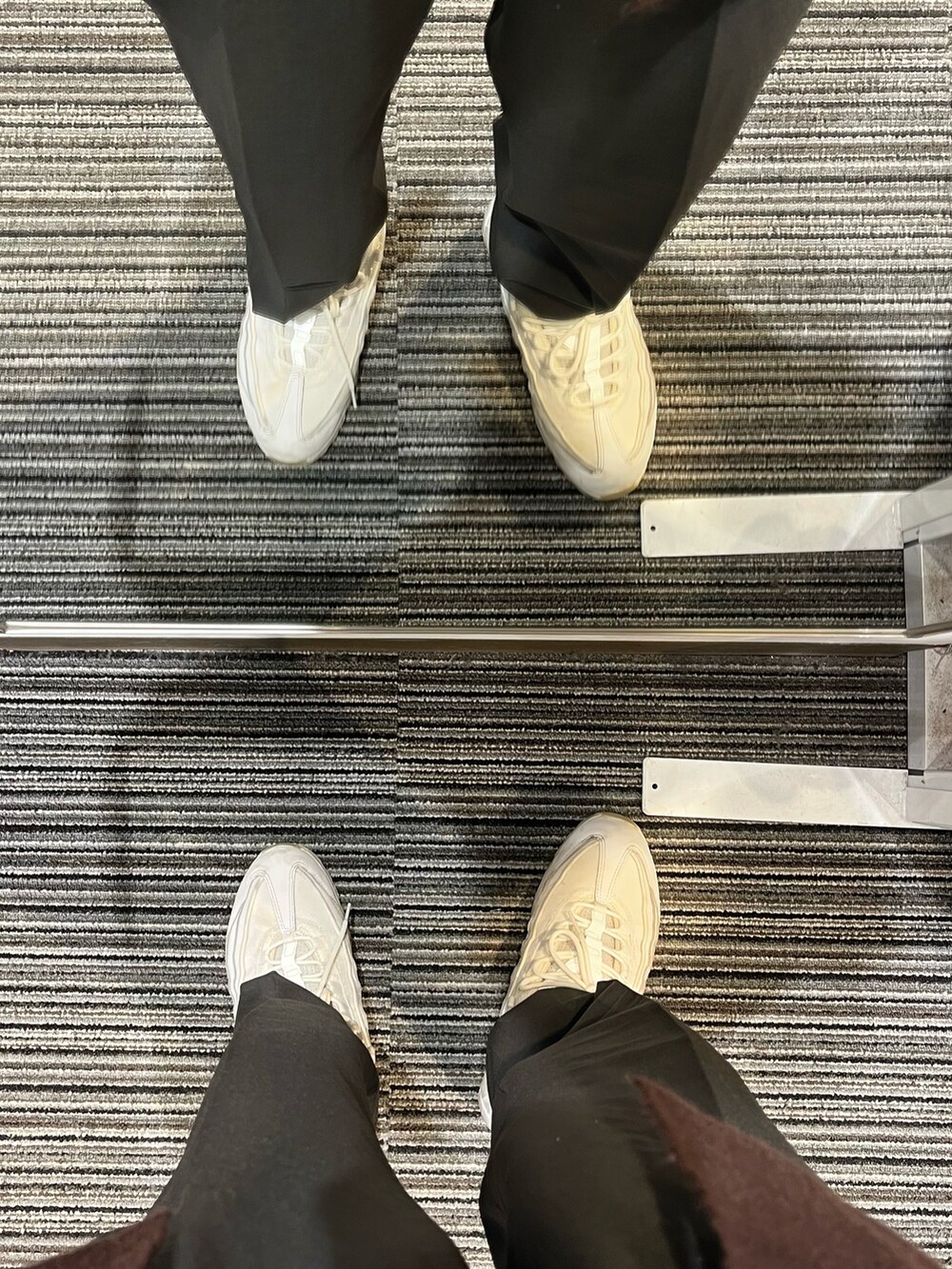 ブラウン系のパンツ、ホワイト系のスニーカー、ホワイト系のシャツ/ブラウスを着用したメンズの冬コーディネートの5枚目の写真