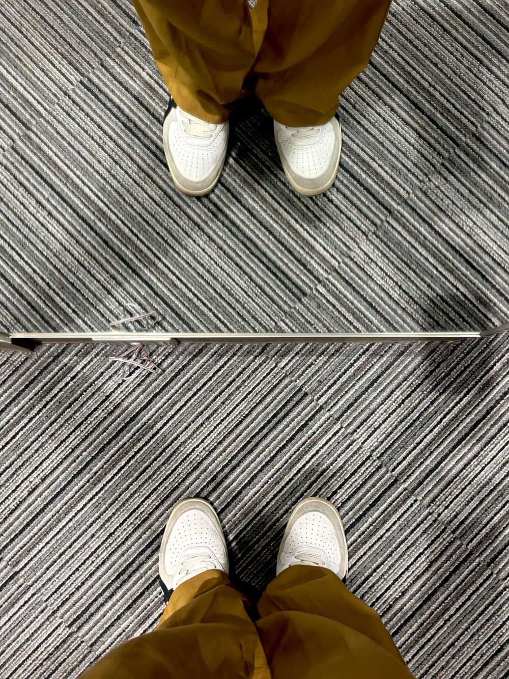 オレンジ系のパンツ、ホワイト系のスニーカー、ブラック系のTシャツ/カットソーを着用したメンズの秋コーディネートの5枚目の写真