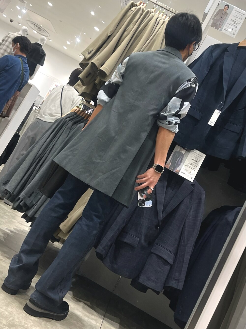 ブラック系のショルダーバッグ、ブラック系のドレスシューズ、ブルー系のデニムパンツを着用したメンズの春コーディネートの2枚目の写真