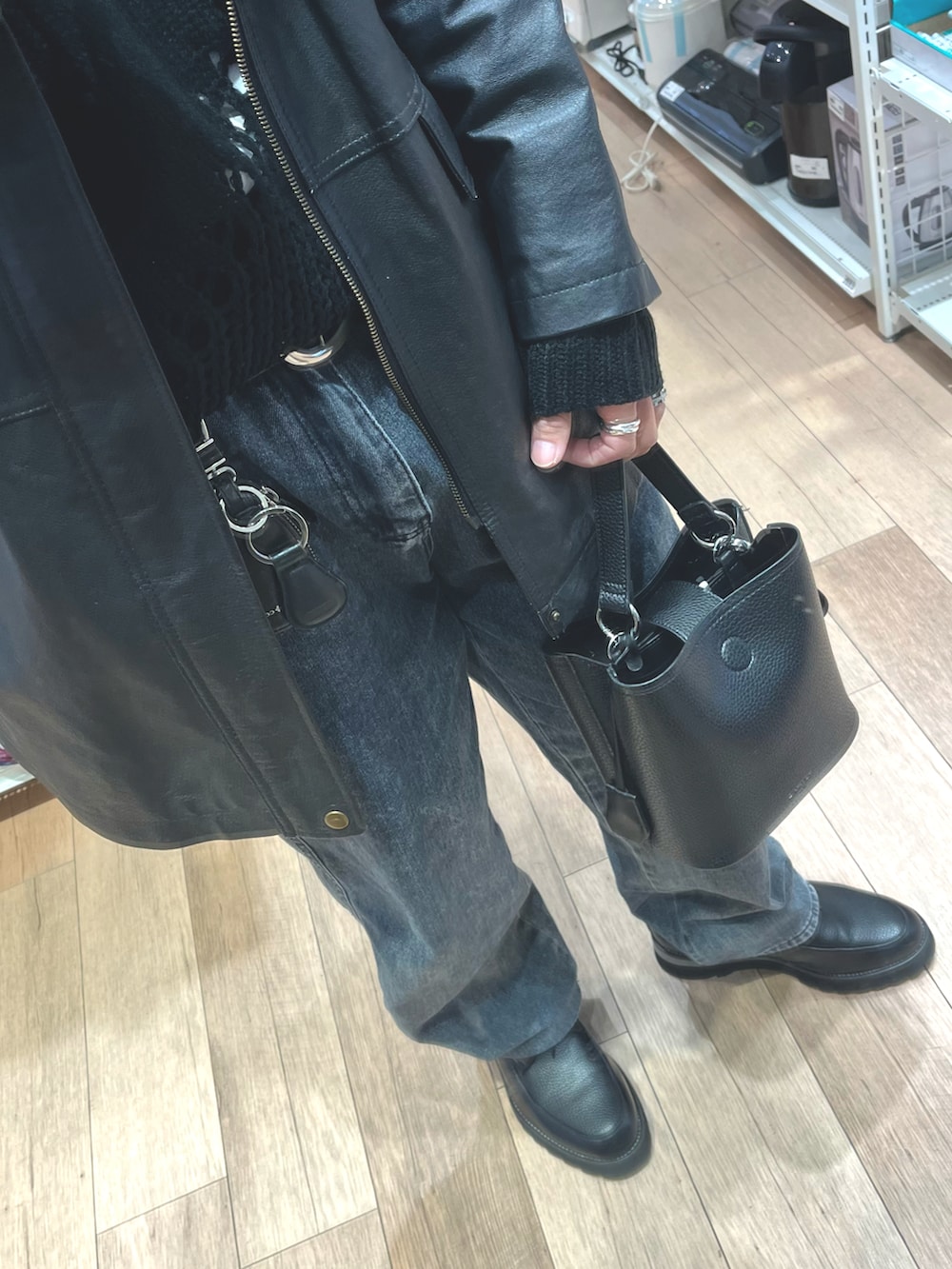 グレー系のデニムパンツ、ブラック系のニット/セーター、ブラック系のドレスシューズを着用したメンズの冬コーディネートの3枚目の写真